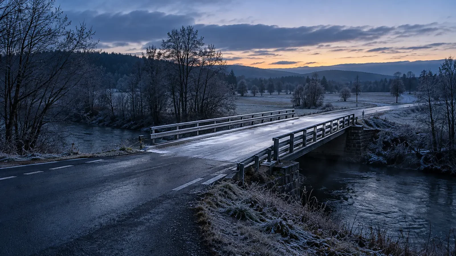 Ponte rurale con un sottile strato di ghiaccio prima dell’alba
